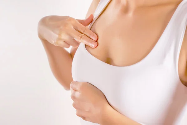 abtasten-brust, © BigmanKn, Shutterstock Weiblicher Oberkörper mit weißem Unterhemd. Frau tastet ihre Brust ab.