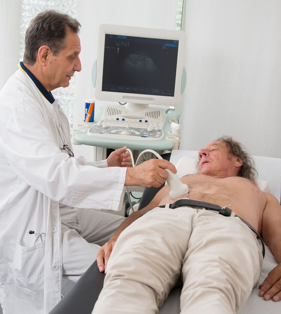Ein Mann liegt auf einem Untersuchungstisch, während ein Arzt eine Ultraschalluntersuchung durchführt.