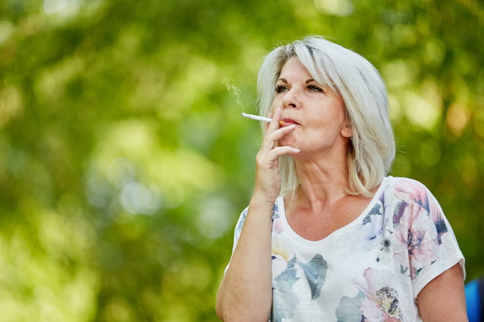 Eine ältere Frau raucht.
