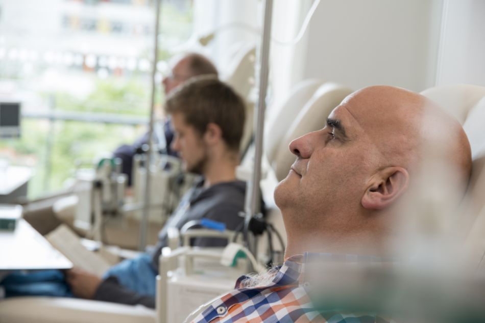Männliche Patienten erhalten Chemotherapie-Infusionen in einer Tagesklinik