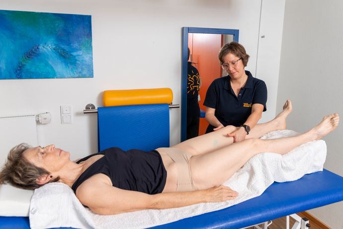 Physiotherapeutin behandelt Frau mit Lymphödem am Bein