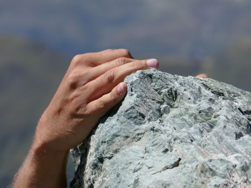 Eine Hand greift beim Klettern um einen Felsblock. © joergweitz, Pixabay