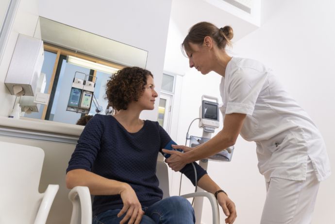 Krankenschwester misst bei Patientin Blutdruck