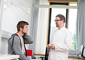 Junger Patient mit Arzt beim Aufklärungsgespräch im Krankenhaus. Foto: Tobias Schwerdt