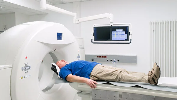 Computertomographie-Untersuchung, © Krebsinformationsdienst, DKFZ; Foto: Tobias Schwerdt Ein Mann liegt auf dem Untersuchungstisch eines Computertomographen.
