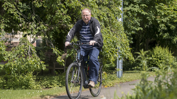 Ein Mann fährt mit dem Fahrrad auf einem Fahrradweg durch die Natur