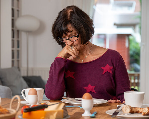 Frau sitzt appetitlos vor dem Frühstück. Bild: Tobias Schwerdt © Krebsinformationsdienst, DKFZ