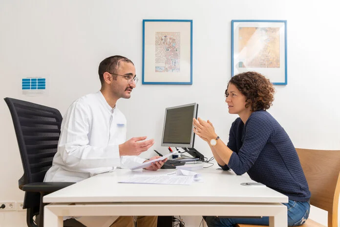 Patientin spricht mit Arzt, © Krebsinformationsdienst, DKFZ; Foto: Tobias Schwerdt Eine junge Frau sitzt einem Arzt am Schreibtisch gegenüber.