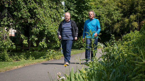Zwei ältere Männer gehen spazieren.