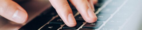 Finger tippen auf einer Cpmputertastatur