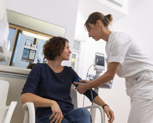 Blutdruck messen , © Krebsinformationsdienst, DKFZ Krankenschwester misst bei Patientin Blutdruck