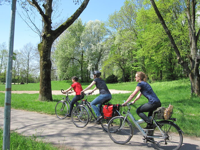 3 Frauen fahren mit dem Fahrrad durch den Park