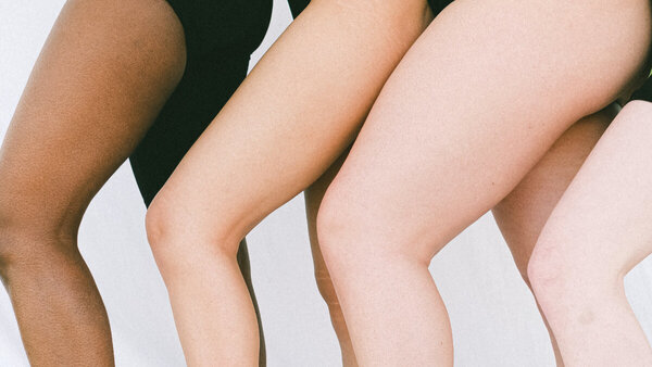 Vier Frauen mit unterschiedlichen Hauttypen zeigen ihre Beine.