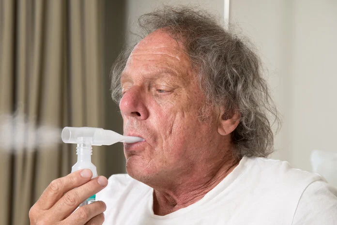 Atemtest, © Krebsinformationsdienst, DKFZ; Foto: Tobias Schwerdt Älterer Mann macht mit einem Atemgerät einen Atemtest.