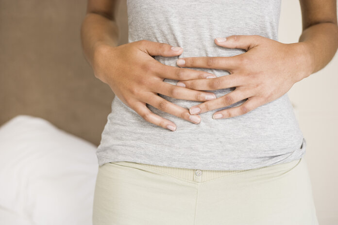 Person hält sich mit beiden Händen den Bauch