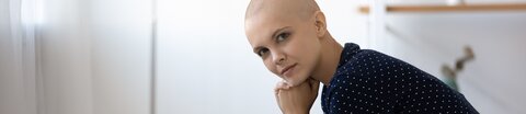 Haarausfall, © fizkes, Shutterstock Junge nachdenkliche Patientin mit Glatze stützt ihren Kopf auf die Hände.
