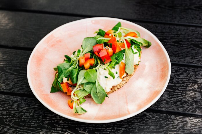 Scheibe Brot mit Frischkäse, Salat und Gemüse