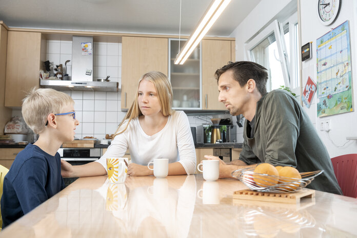 Eltern-Kind-Gespraech, © Krebsinformationsdienst, DKFZ; Foto: Tobias Schwerdt Eine junge Frau und ein Mann sitzen im Gespräch mit einem Kind am Tisch