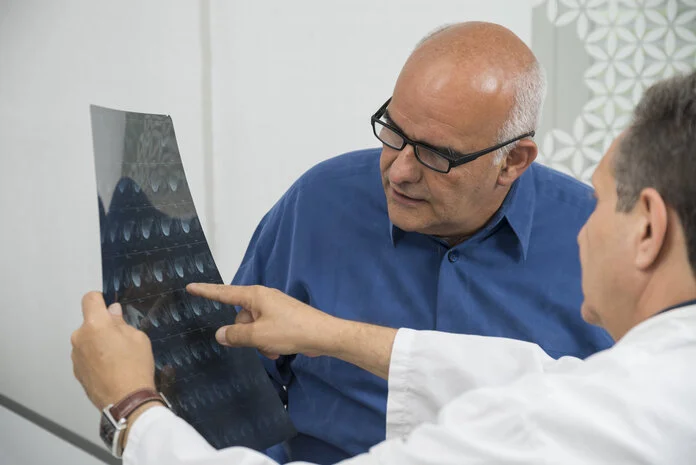 Röntgenaufnahme, © Krebsinformationsdienst, DKFZ; Foto: Tobias Schwerdt Ein Arzt erklärt einem Patienten eine Röntgenaufnahme.