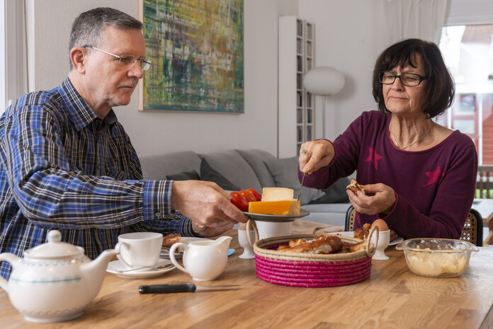 Ein Mann und eine Frau sitzen beim Früstück im Esszimmer.