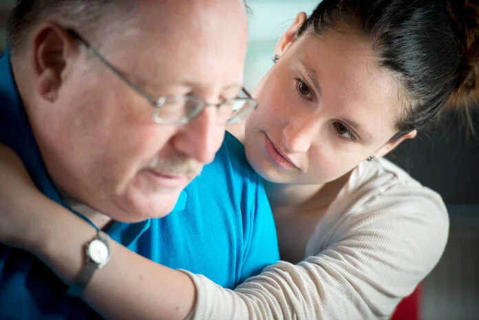Beistand bei Krankheitsbewältigung, © Krebsinformationsdienst, DKFZ; Foto: Tobias Schwerdt Eine Frau umarmt einen Mann als Symbol für die Unterstützung durch Angehörige bei einer Krebserkrankung.
