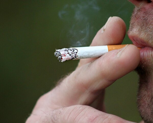 Ein Mann zieht an einer Zigarette.