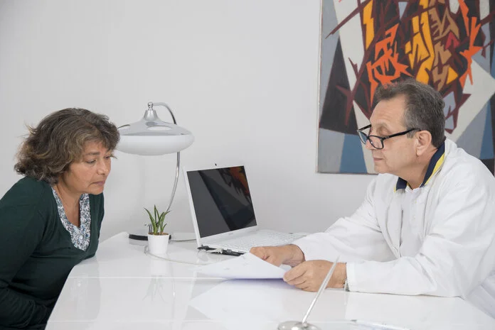 Arzt erklärt Frau Befund. , © Krebsinformationsdienst, DKFZ; Foto: Tobias Schwerdt Eine Frau bekommt vom Arzt ihren Befund erklärt.