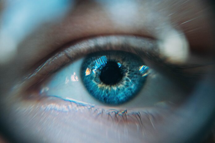 Auge mit blauer Iris in Nahaufnahme