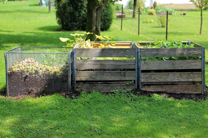 Drei verschieden große Kompostbehältnisse im Garten