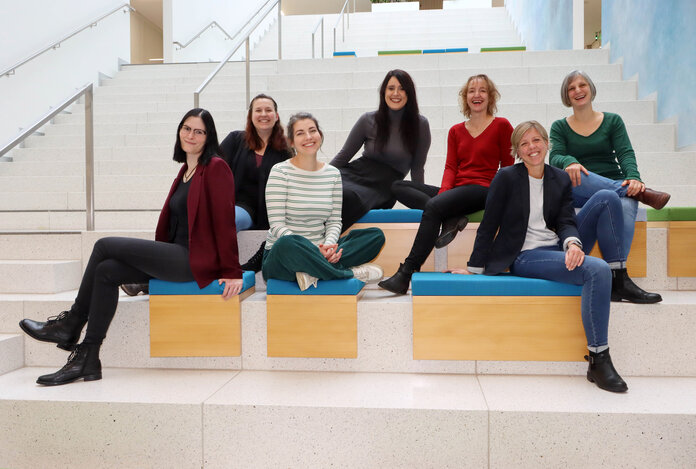 Teamfoto der Mitarbeiterinnen der Internet- und Social Media Redaktion des Krebsinformationsdienstes sitzend auf einer Treppe.