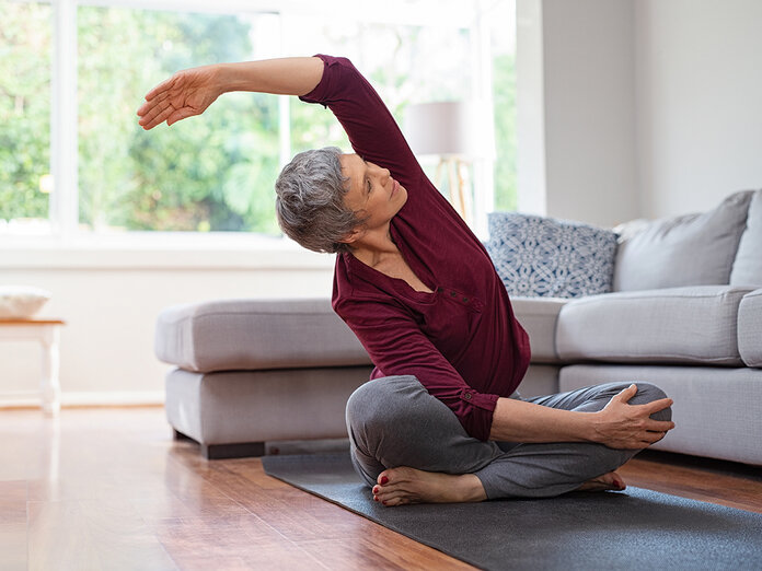 Ältere Frau macht Yoga im Wohnzimmer © Rido, Shutterstock