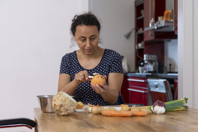 Eine Frau schält Gemüse.