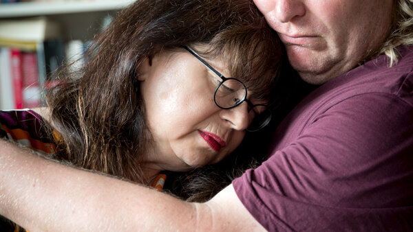 Ein trauriges Paar umarmt sich.