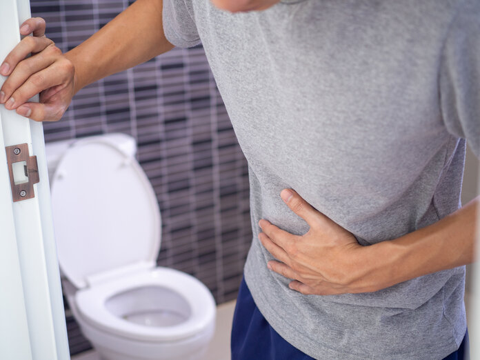 Mann bei Toilette hat Bauchschmerzen