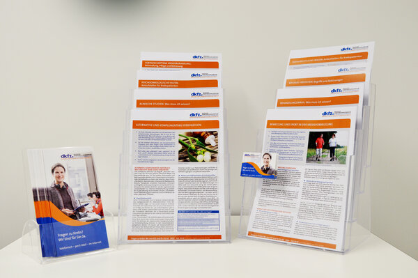 Tisch mit Flyern und Informationsblättern zum Thema Krebs sowie eine Visitenkarte des Krebsinformationsdienstes.