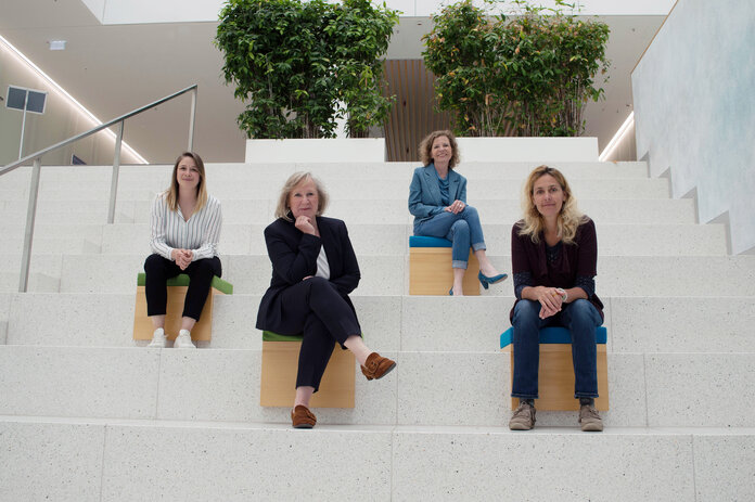 Die 4 Mitarbeiterinnen von Kommunikation und Outreach des Krebsinformationsdienstes sitzen zu einem Gruppenbild auf einer Trreppe.