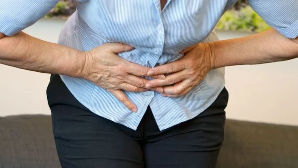 Unterleibschmerzen, © lunopark, Shutterstock Frau hält sich schmerzgekrümmt die Hände an den Unterleib