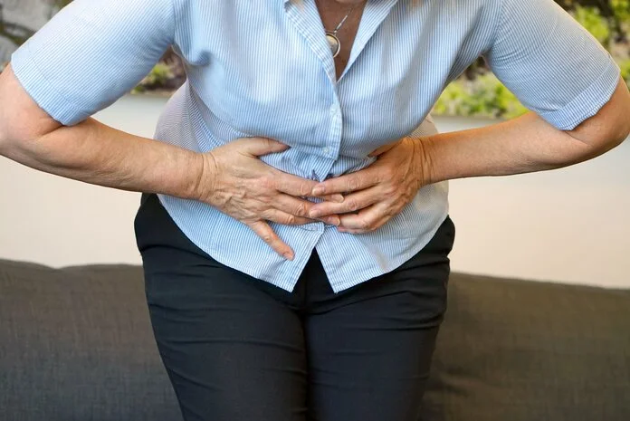 Unterleibschmerzen, © lunopark, Shutterstock Frau hält sich schmerzgekrümmt die Hände an den Unterleib
