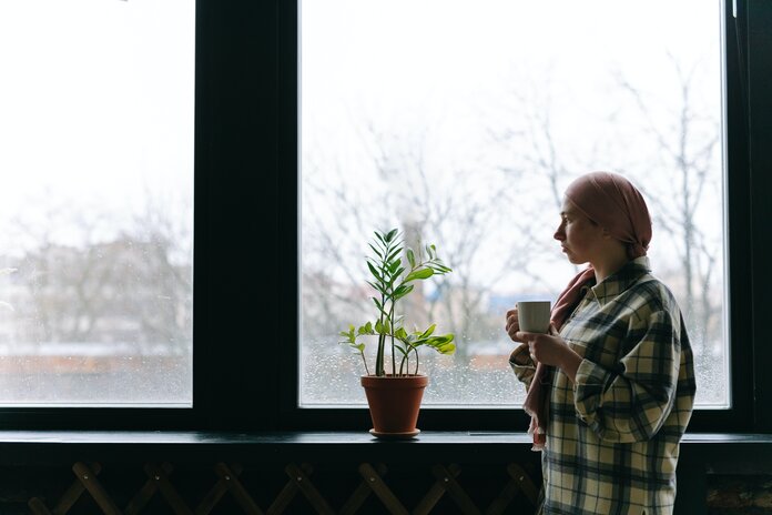 Junge Patientin schaut nachdenklich aus dem Fenster.