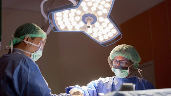 Ärzte-Operation, © I AM NIKOM, Shutterstock Zwei Ärzte operieren.