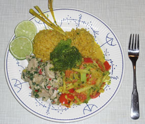 Teller mit Reis, Gemüse und einer Curry-Soße